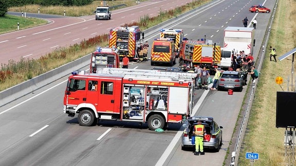 Feuerwehrautos blockieren eine Autobahn wegen eines Unfalls.