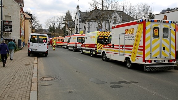 Zahlreiche Krankenwagen stehen in einer Straße in Weida, nachdem mehrere Menschen eines Seniorenheims in Weida über Atemnot klagten