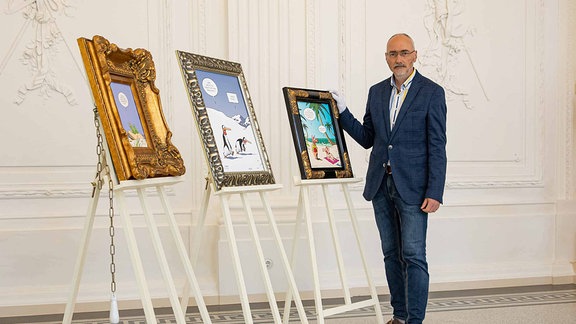 Museumsleiter Herr Ulf Häder steht im Sommerpalais neben Bildern der Ausstellung «Tetsche - saukomisch»