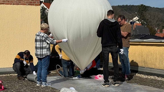 Mehrere Menschen bereiten einen Stratosphärenballon vor
