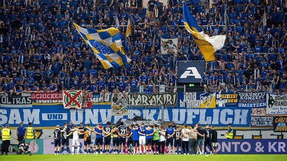 Fans von Jena in der Südkurve feiern ihre Mannschaft nach dem Spiel