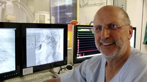 Ein Mann sitzt im Herz-Labor vor einem Monitor.
