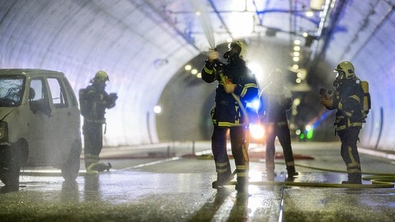 Einsatzkräfte der Feuerwehr üben den Löschvorgang des Fahrzeugs. 