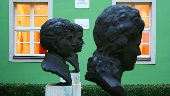 Skulpturen vor einem grünen Haus
