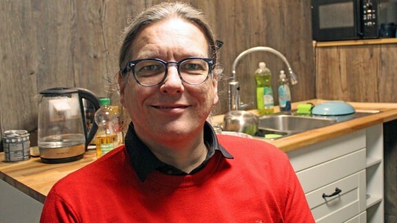 Der Leiter der Wohngruppe in Jena, ein Mann mit Brille und roten Pulli