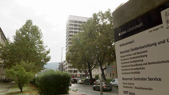 Ein Hochhaus im Hintergrund, davor ein Schild der Stadtverwaltung.