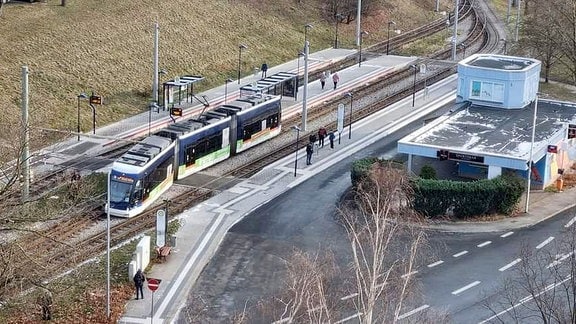 Eine vordere Teil einer Straßenbahn steht neben den Schienen. 