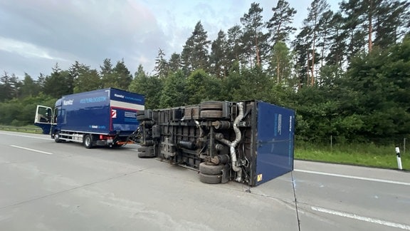 Unfallstelle mit umgekipptem Lastwagen-Anhänger auf der Autobahn