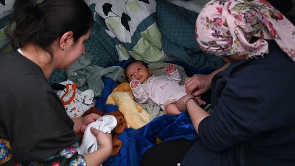 Zwei aus der Türkei geflüchtete Frauen kümmern sich in einem der Zelte der Flüchtlingsunterkunft um ein 1 Monate altes Baby