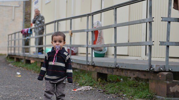 Ein Kleinkind steht auf dem Gelände der Erstaufnahmestelle für Flüchtlinge