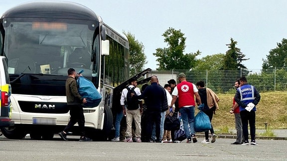 Menschen stehen neben einem Bus