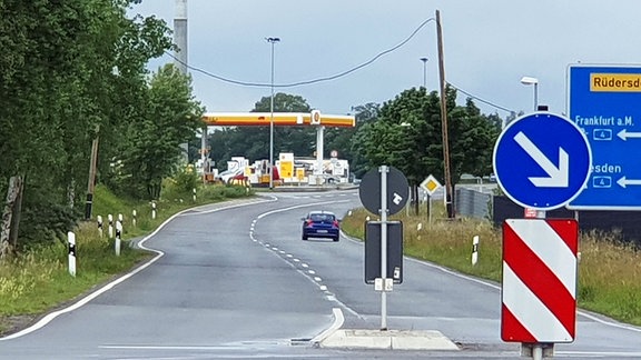 Eine Straße führt zu einer Tankstelle.
