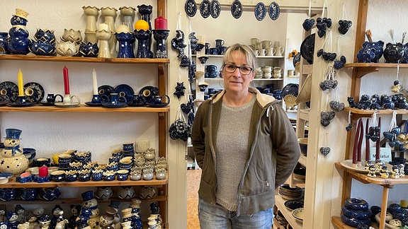 Eine Frau steht in einem Laden für keramikprodukte.