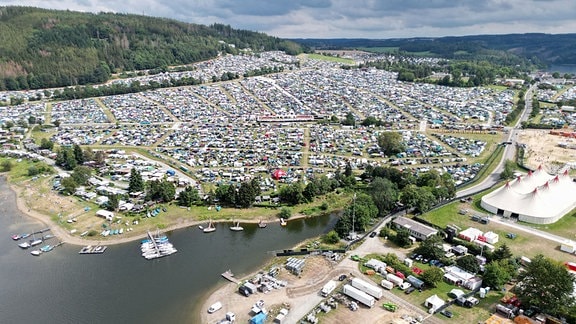 Zahlreiche Zelte und Wohnmobile stehen auf den Wiesen und Felder rund um das Festivalgelände