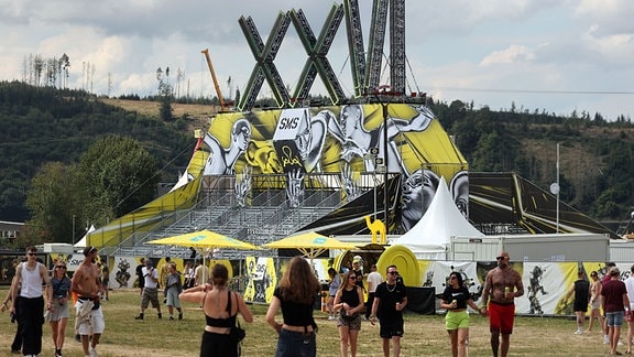 Besucher kommen auf das Festivalgelände vor dem Beginn des Techno-Festivals "SonneMondSterne" 