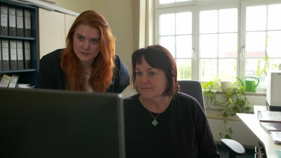 Zwei Frauen schauen auf einen Bildschirm