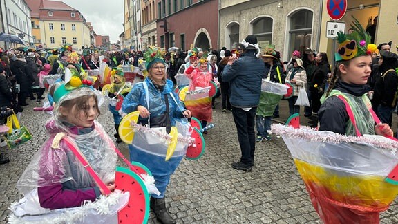 Eine Gruppe von verkleideten Frauen tanzt über die Straße