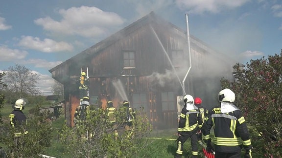Feuerwehrleute bekämpfen einen Hausbrand.
