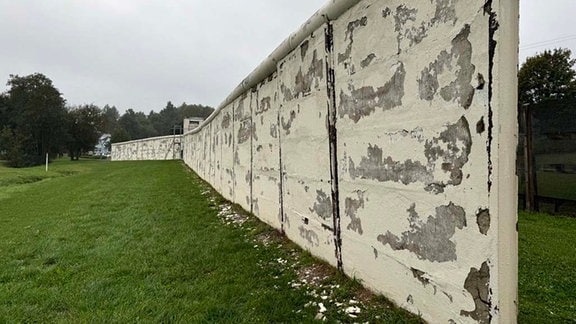 Von einer Mauer bröckelt der Putz ab