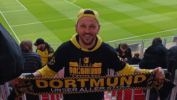 Michél Schulze im Stadion mit einem BVB-Schal.