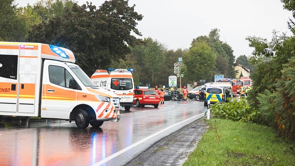 Unfallstelle mit schwer beschädigten Fahrzeugen und Einsatzkräften