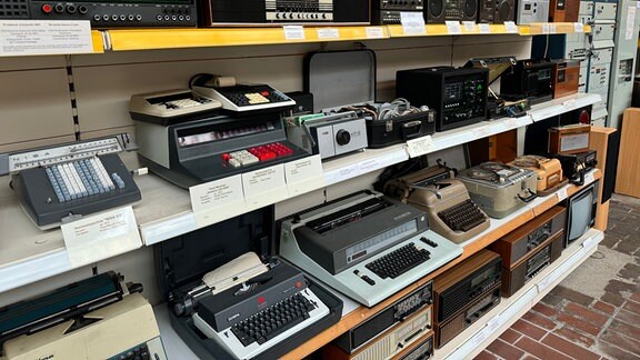 Alte Schreibmaschinen und Radios in einem Regal