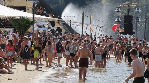 Zahlreiche Besucher des Techno-Festivals "SonneMondSterne" an der Bleilochtalsperre baden vor Beginn des Konzertes