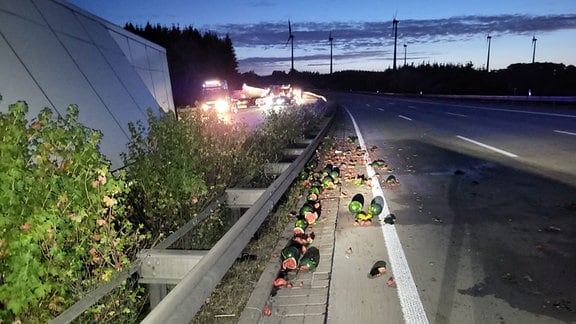 Zerplatzte Melonen liegen neben einer Autobahn.