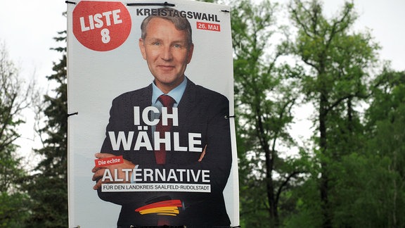 Ein Plakat hängt an einem Laternenmast. Es zeigt Björn Höcke in einem schwarzen Anzug. Die Aufschrift lautet "Ich wähle die echte Alternatie für den Landkreis Saalfeld-Rudolstadt". 