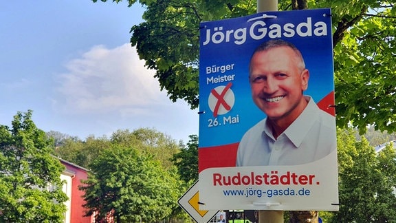 Ein Mann lächelt auf einem Wahlplakat.