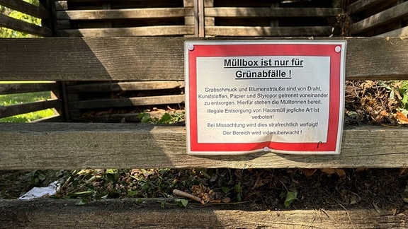 Ein Schuld hängt an einem Kompost.