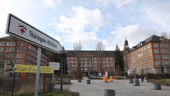 Ein Schild weist auf den Eingang der Thüringen Kliniken hin