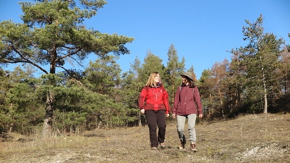 Zwei Frauen wandern durch eine Thüringer Landschaft.