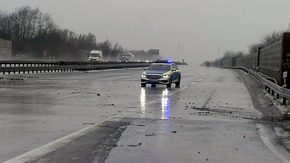 Ein Polizeiauto steht auf einer gesperrten Autobahn.