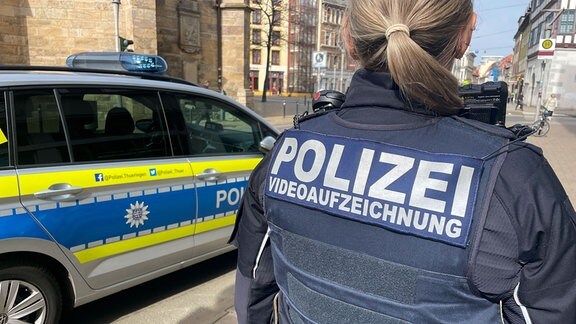 Eine Thüringer Polizeibeamtin in Schutzweste, auf der die Worte Polizei und Videoaufzeichnung aufgedruckt sind.