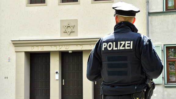 Ein Polizist steht vor dem Eingang zur Neuen Synagoge in Erfurt