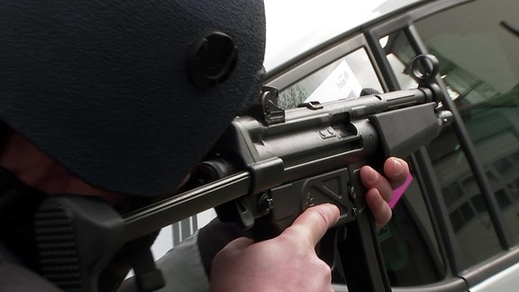 Ein Polizeibeamter der LPI Erfurt hält eine MP5 im Anschlag