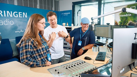 Eine Frau und zwei Männer in einem Radiostudio