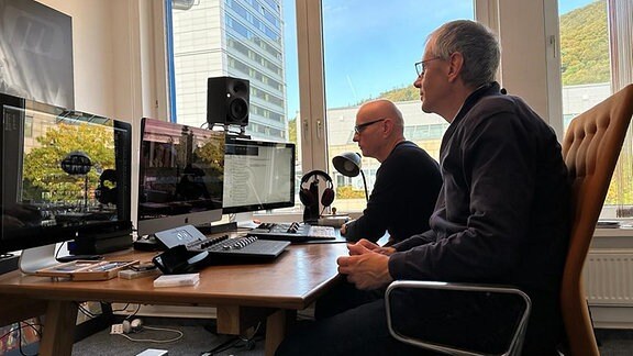 Zwei Männer sitzen an einem Schreibtisch