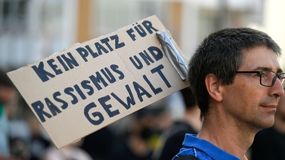 Eine Mann auf einer Demonstration mit einem Plakat