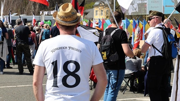 «Königreich Preußen -18» steht auf dem Shirt eines Teilnehmers einer Kundgebung von «Reichsbürgern» auf dem Versammlungsplatz.