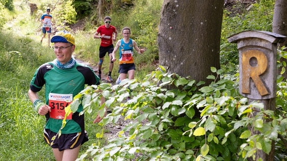 Läufer sind beim 51. GutsMuths-Rennsteiglauf 2024 auf der anspruchsvollen Marathon-Strecke bei Masserberg unterwegs.