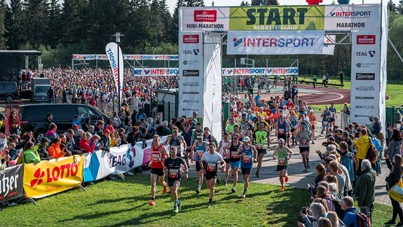 Die ersten der circa 3500 Läufer und Läuferinnen laufen durch das Start-Tor beim Rennsteig-Marathon.