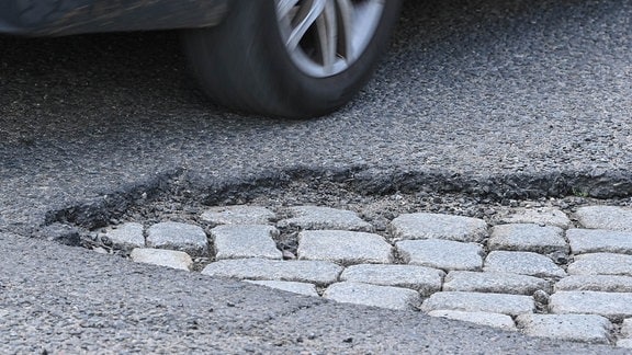 Ein Schlagloch im Asphalt einer Straße