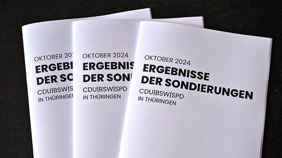 Eine Druckschrift mit dem Titel „Ergebnisse der Sondierungen“ werden während einer Pressekonferenz zu den Ergebnissen der Sondierungsgespräche zwischen CDU, BSW und SPD in der Erfurter Zentralheize präsentiert.