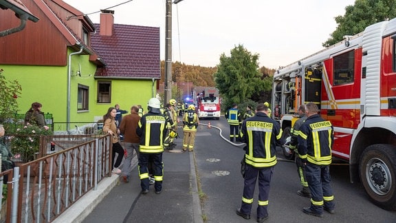 Feuerwehrleute löschen einen Brand in Ahlstädt im Kreis Hildburghausen