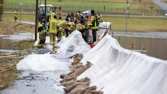 Feuerwehrleute versuchen Hochwasser aufzuhalten.