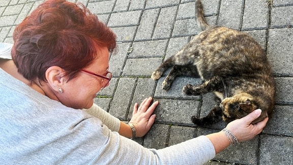 Eine Frau streichelt eine Katze.