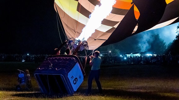 Heißluftballonfahrer heizen die Luft im Heißluftballon mit einem Gasbrenner auf.