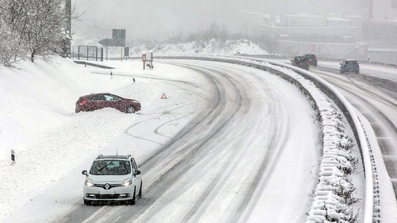 Ein durch Schnee abgekommenes Auto neben einer Autobahn. 